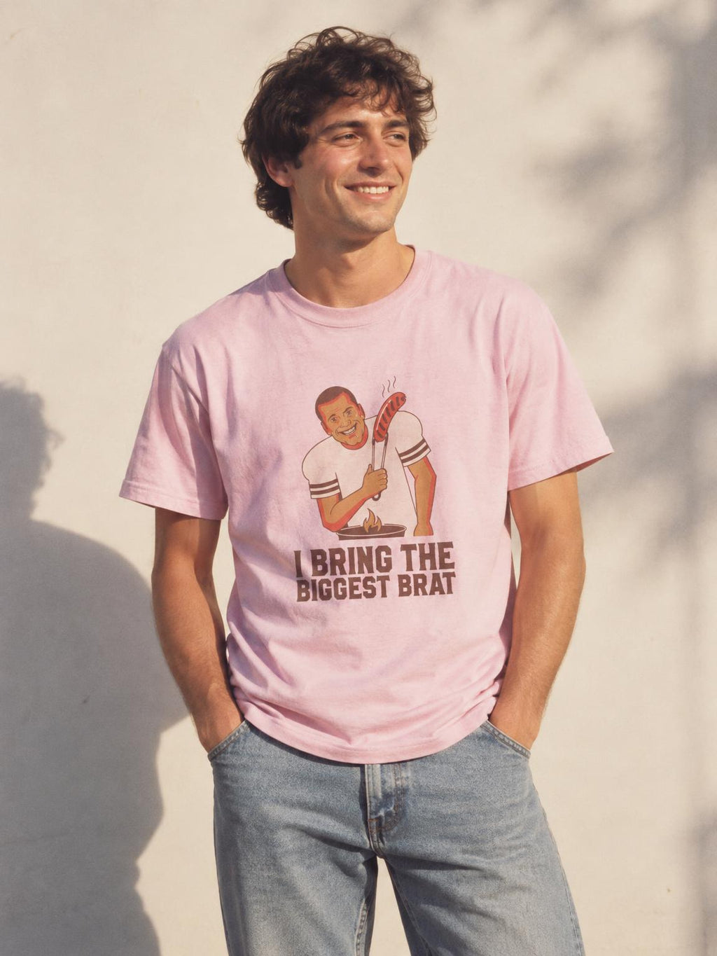 Funny BBQ Grilling T-Shirt - I Bring The Biggest Brat Tee in Light Pink – worn by a man