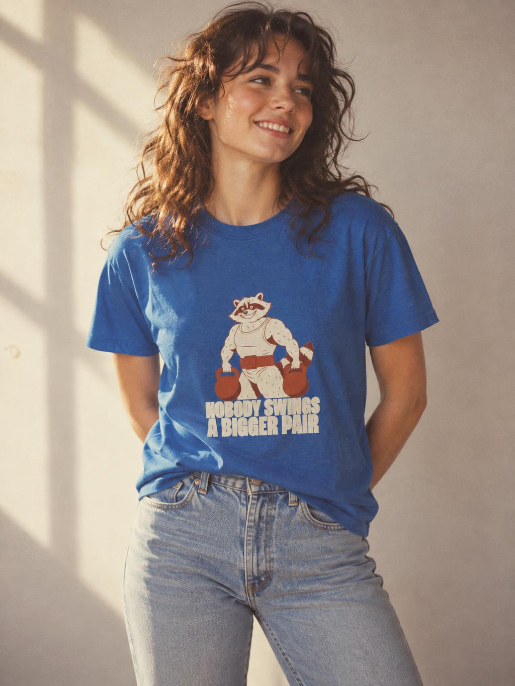 Bulking Season Kettlebell Raccoon Funny Gym Humor T-Shirt in Royal – worn by a woman