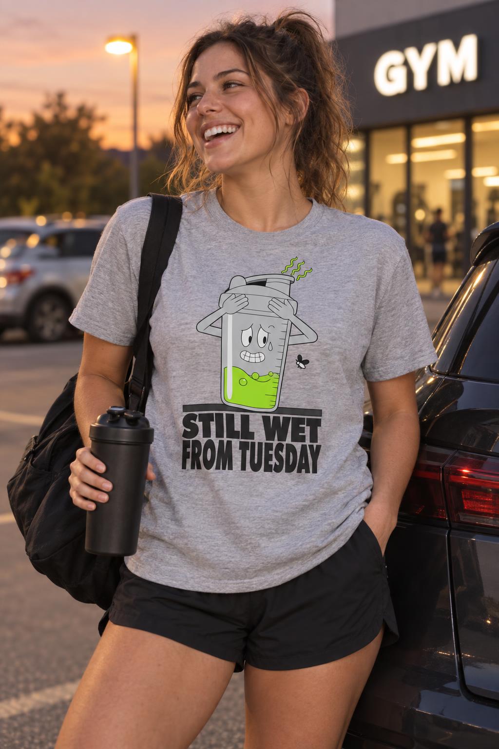 Still Wet From Tuesday Funny Protein Shaker Gym Meme T-Shirt in Sport Grey – worn by a woman