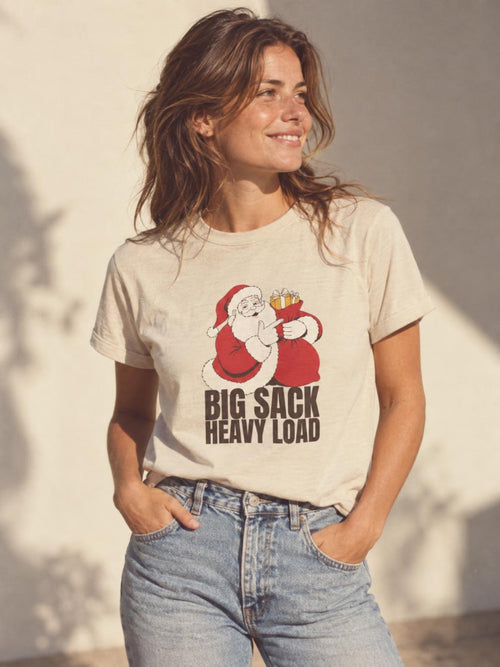 Big Sack Heavy Load Funny Santa White Elephant Gift T-Shirt in Sand – worn by a woman