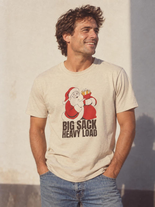 Big Sack Heavy Load Funny Santa White Elephant Gift T-Shirt in Sand – worn by a man